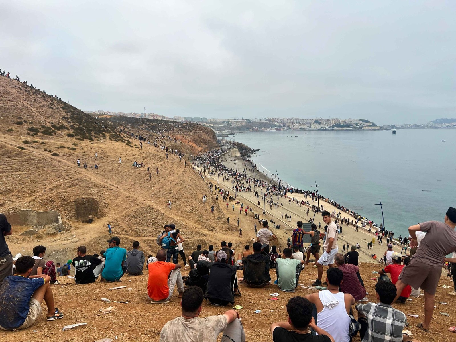 Un grupo de personas evalúa desde Marruecos si todavía alcanza a cruzar después de que la policía empezara a contener a los migrantes en la frontera el pasado 31 de julio