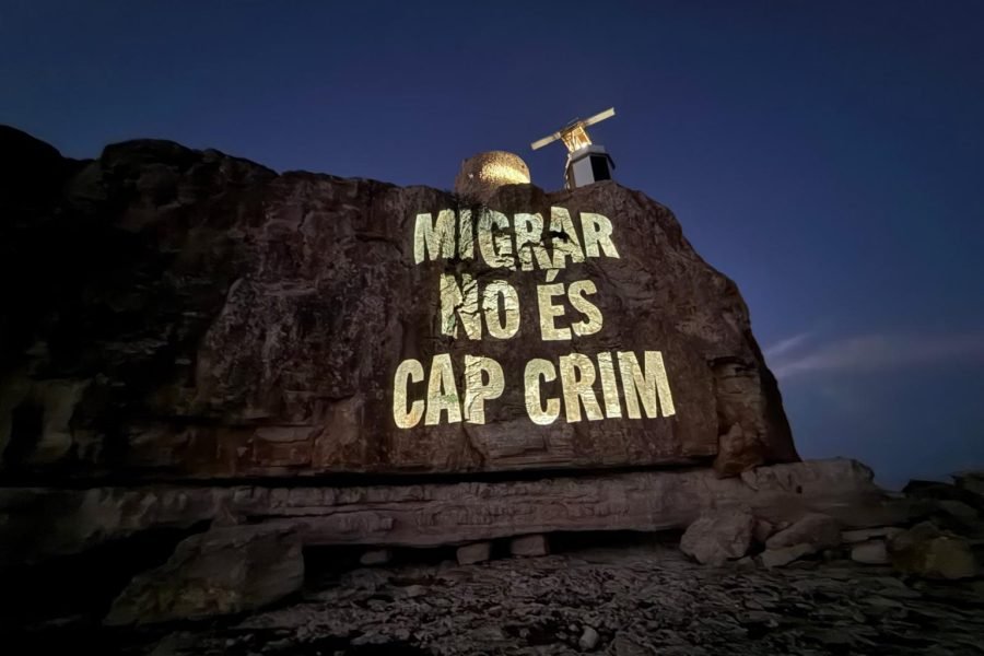 Proyección del Grupo de Acción Antifronteras Laissez Passer, en el marco de una campaña que, en verano de 2025, proyectó en la Torre de en Beu -donde se encuentra el IVE, el radar del sistema de vigilancia de embarcaciones marítimas-, da la bienvenida a las personas migrantes en 22 idiomas. | Fotografía de Laissez Passer